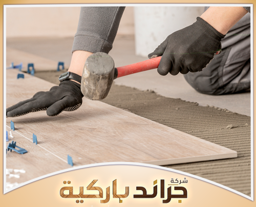 فني ومعلم تركيب باركيه بالرياض 0542860739 جراند باركيه فنيًا يستخدم مطرقة لتثبيت ألواح الباركيه على الأرضية بشكل دقيق، مما يعكس حرص جراند باركيه على تركيب باركيه بالرياض