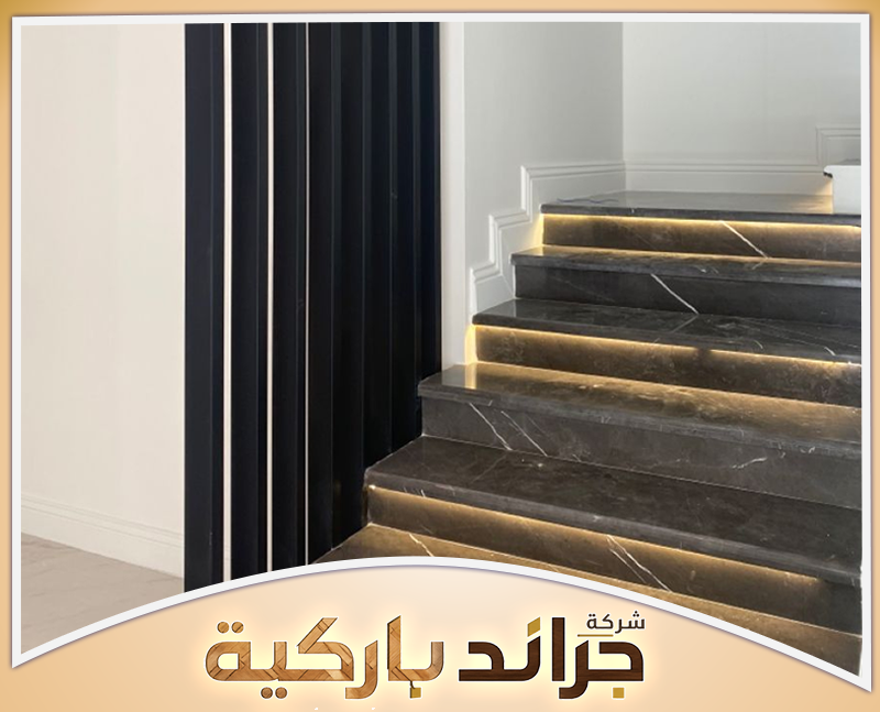 خطوات تركيب البارتشن بالرياض | 0542860739 جراند باركيه بارتشن أسود بشرائح رأسية بجوار درج رخامي بإضاءة مخفية في منزل حديث وأنيق بالرياض.